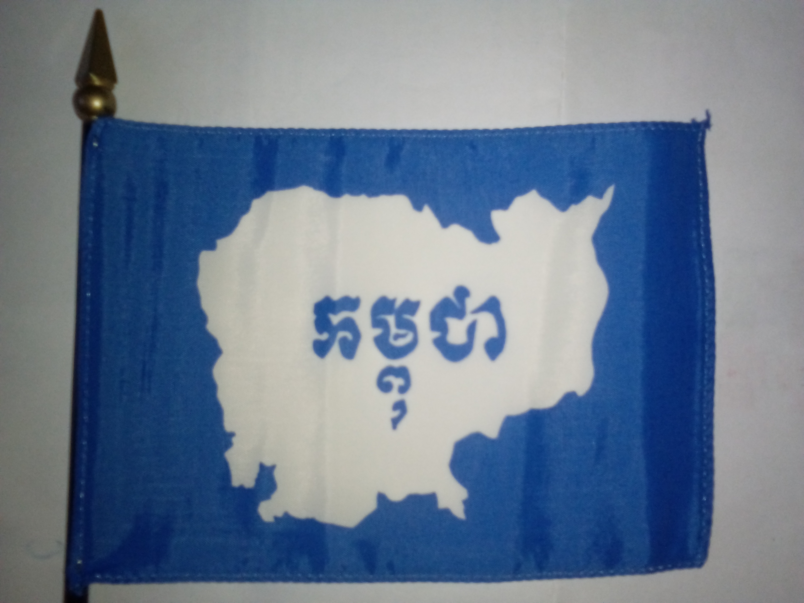 Vintage miniature desk flag of the United Nations Transitional Authority in Cambodia (UNTAC), 1991-1993 era.